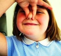 Niña pellizcando su nariz